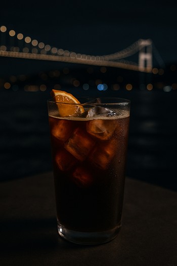 Gece Boğaz manzarasına karşı tutulan cold brew bardağı