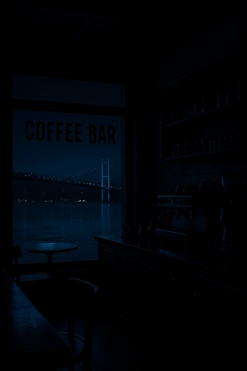 Işıkları kısılmış mekân ve camda yansıyan Boğaz manzarası